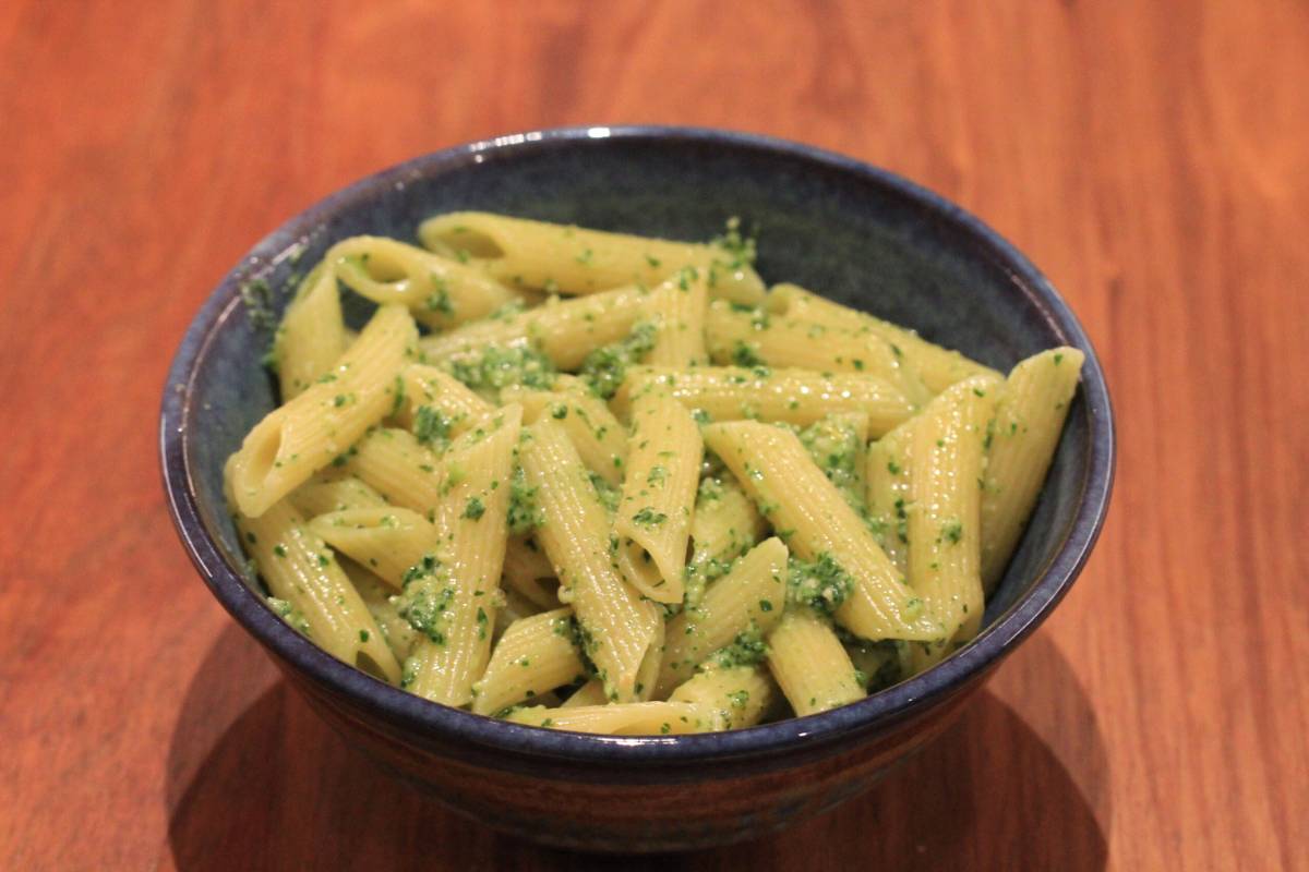 A bowl of pasta with carrot top pesto