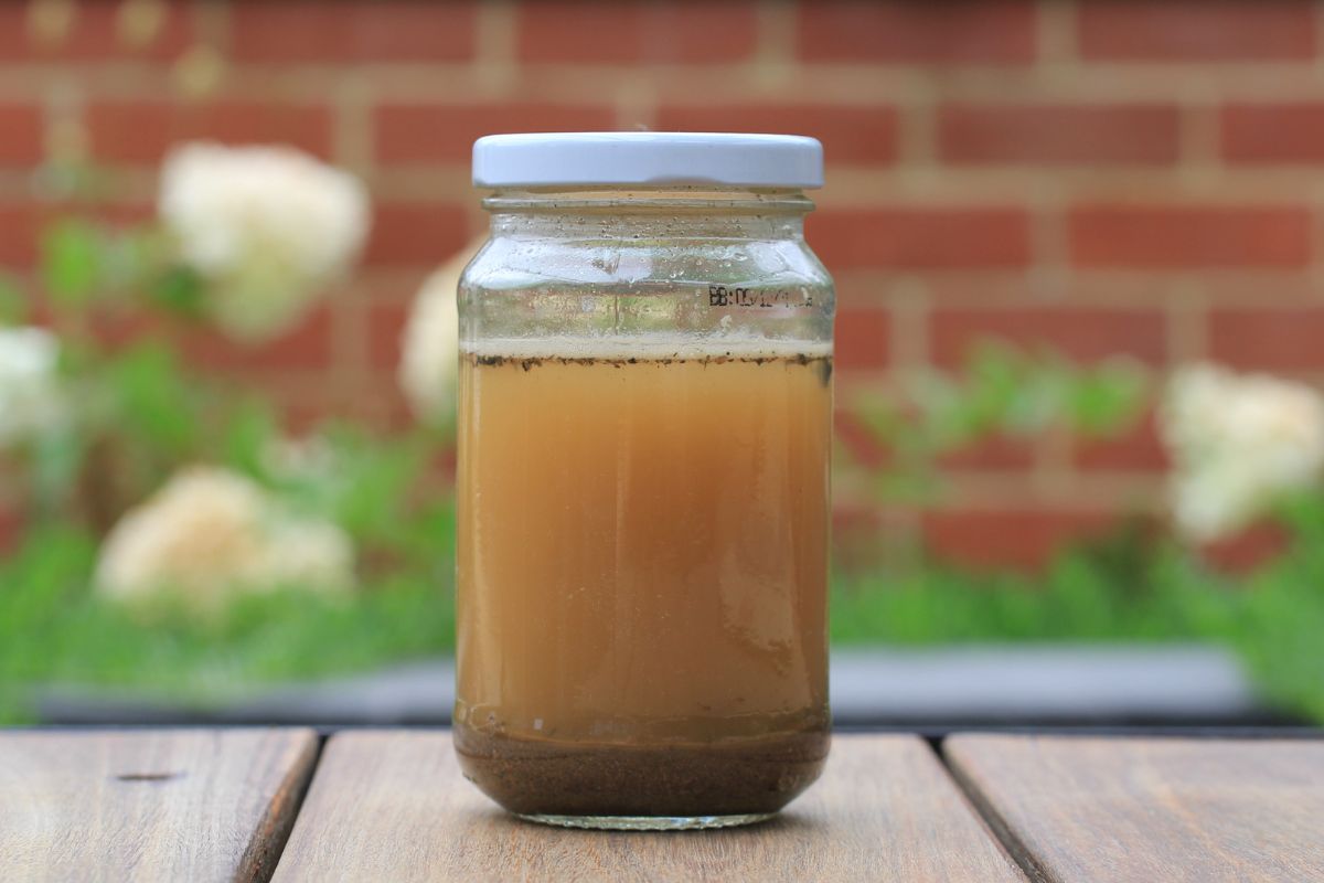 A jar of clay soil and murky water used to conduct a dispersive soil type test