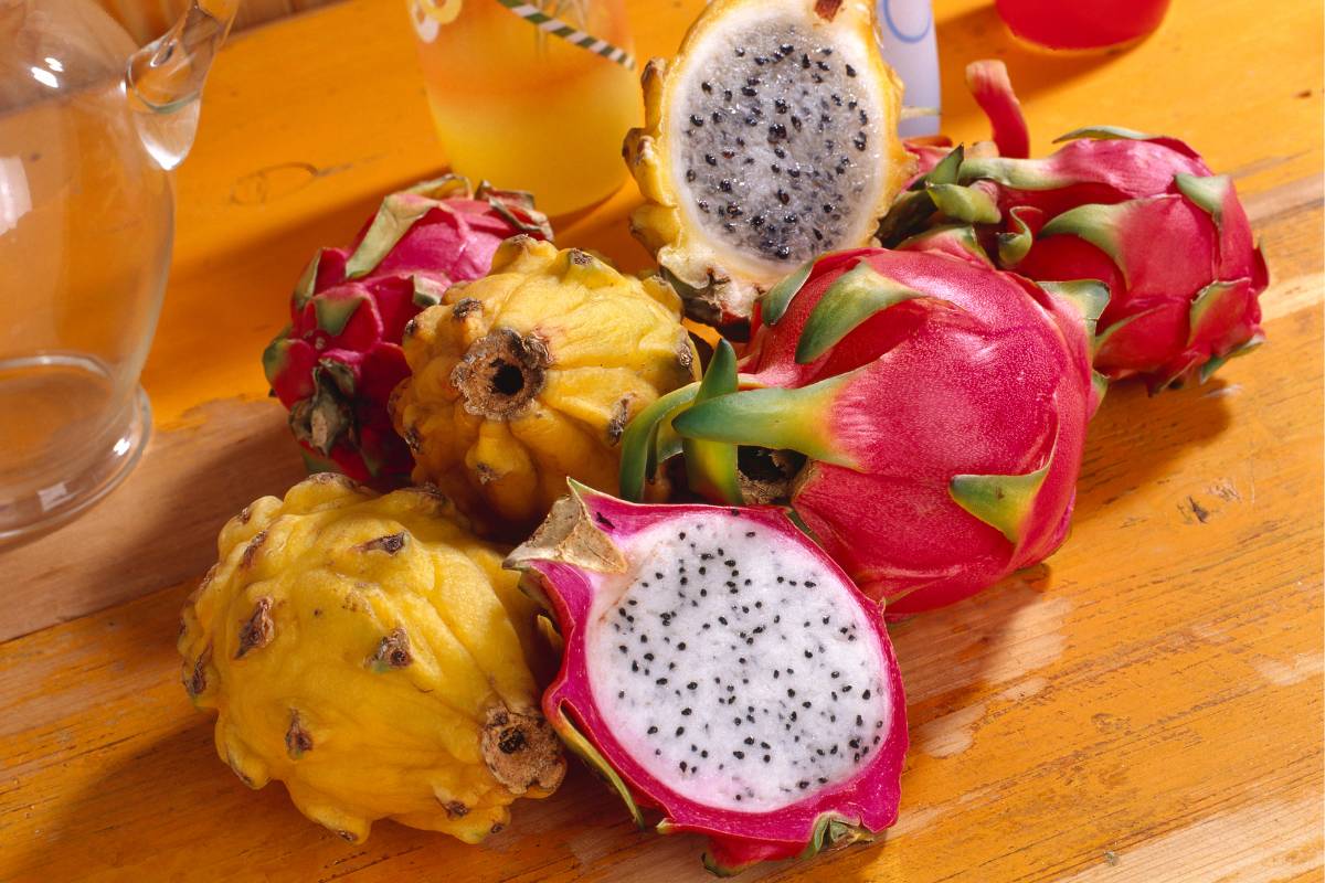 Harvested yellow and red dragon fruit cut open to show the white flesh and seeds