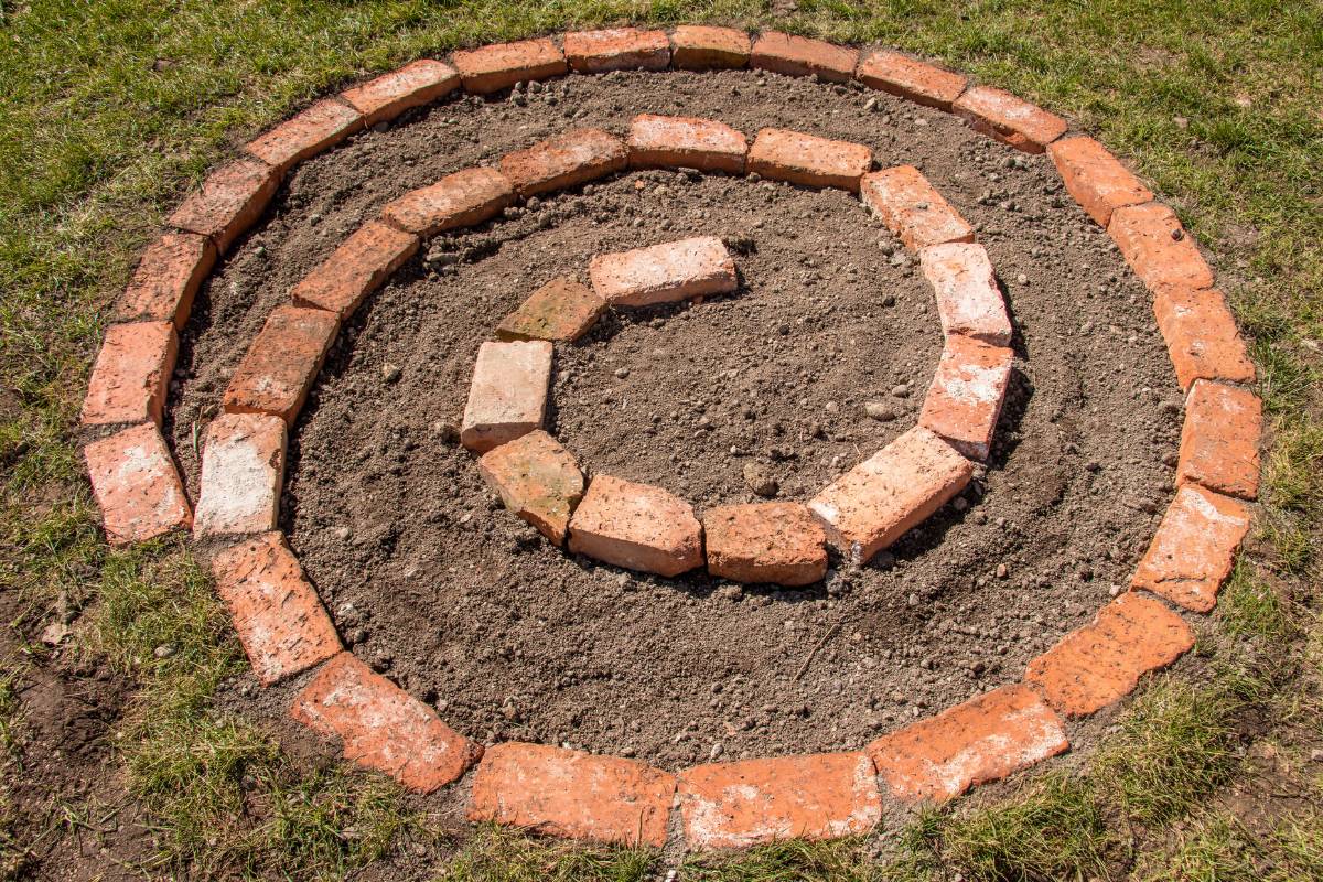 A single layer of bricks laid out to form a spiral herb garden