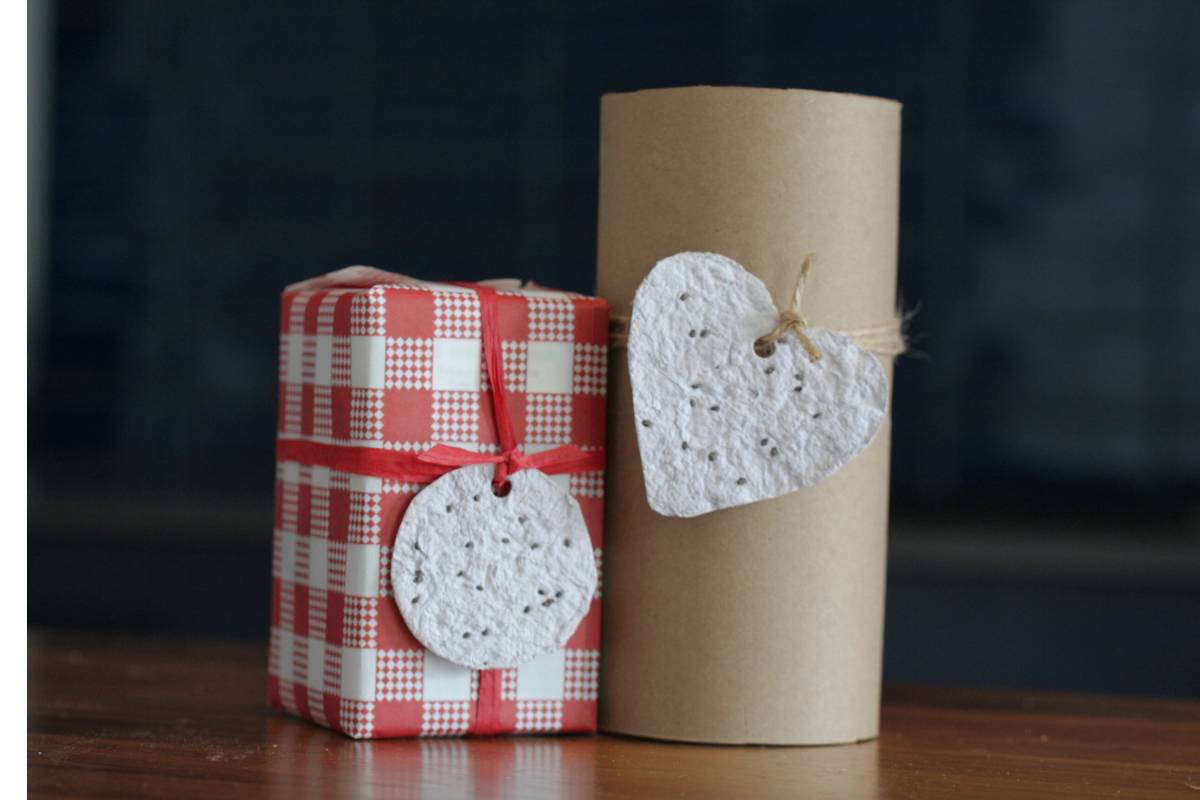 Two wrapped gifts with seed paper gift tags attached with string.