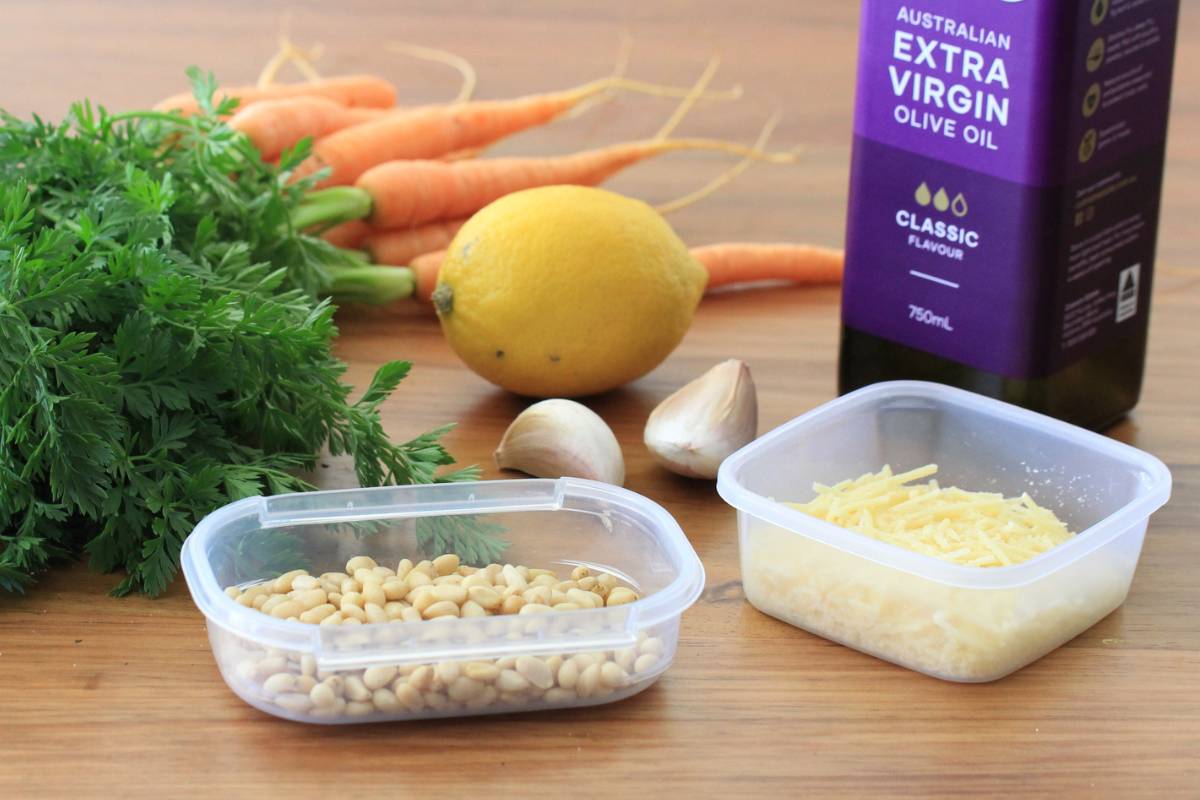 Ingredients for carrot top pesto: carrot leaves, garlic, pine nuts, parmesan cheese, olive oil and lemon juice