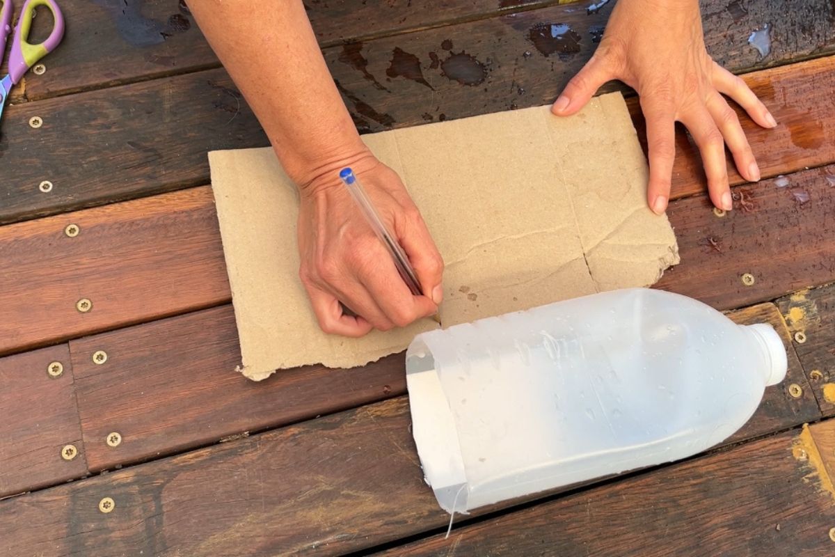 Measuring the cardboard against the bottle