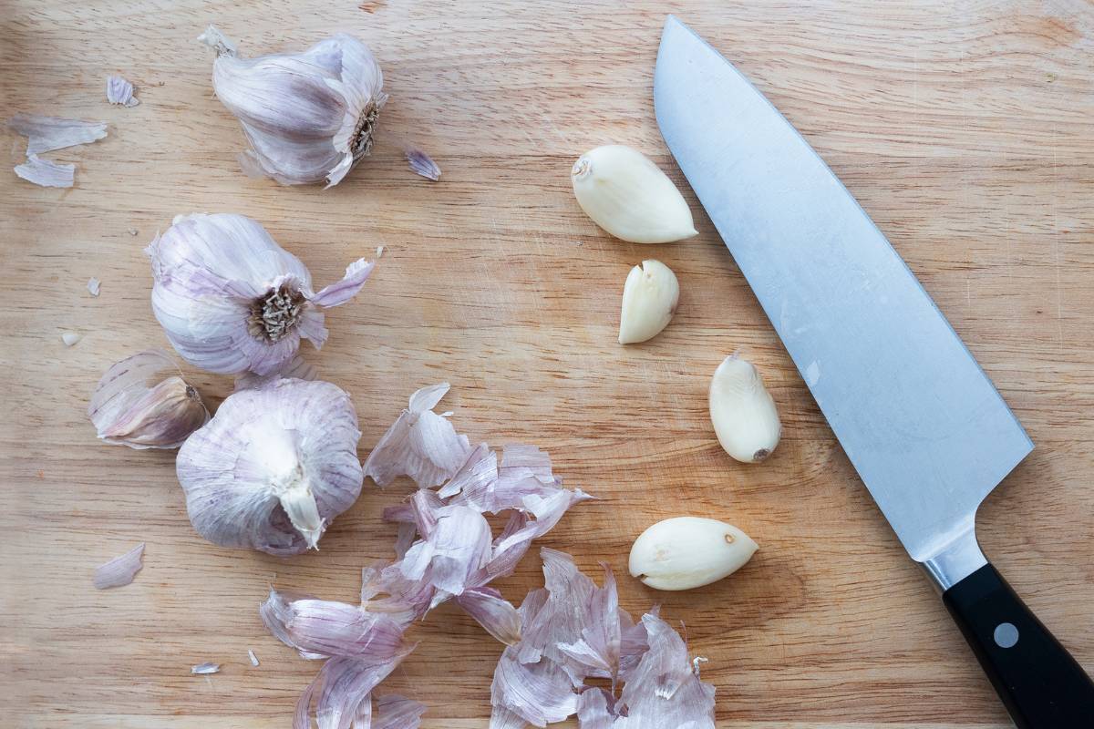 Peeled garlic cloves on a chopping board