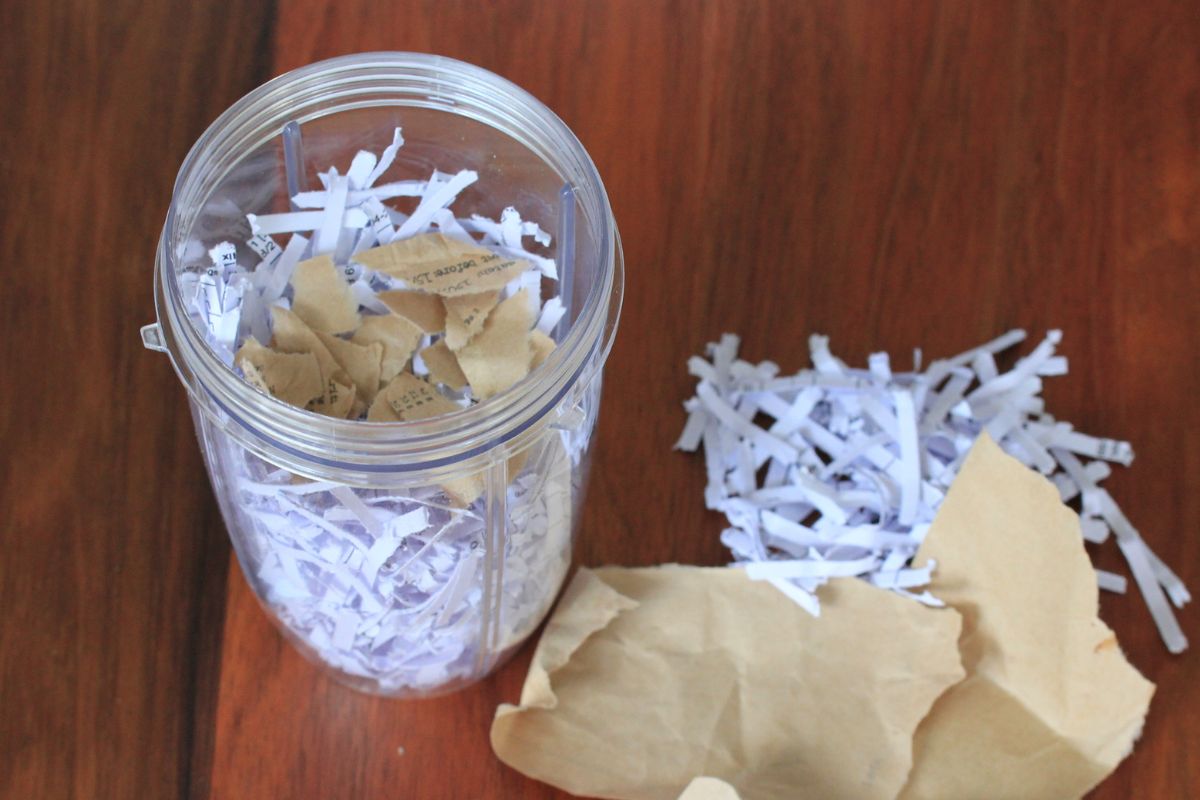Shredded and torn paper in a blender bowl.