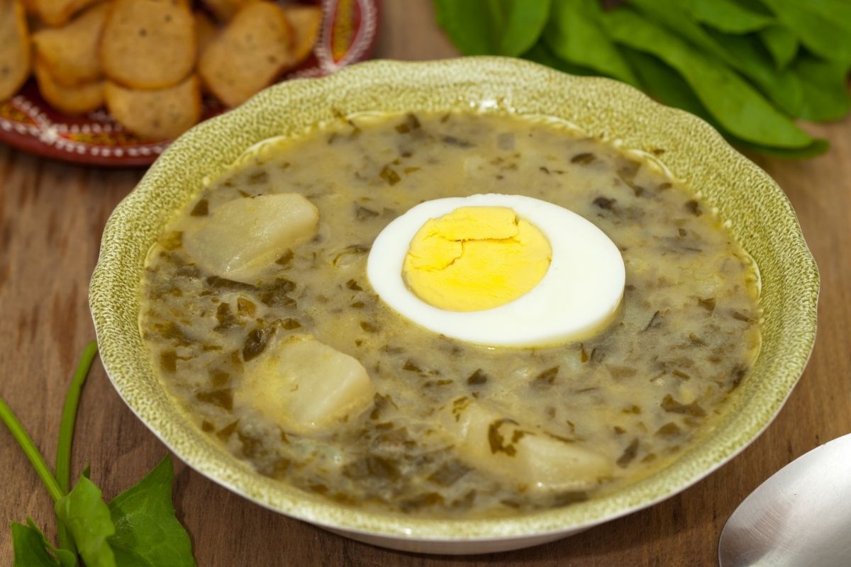 A bowl of rustic sorrel soup with half a boiled egg 