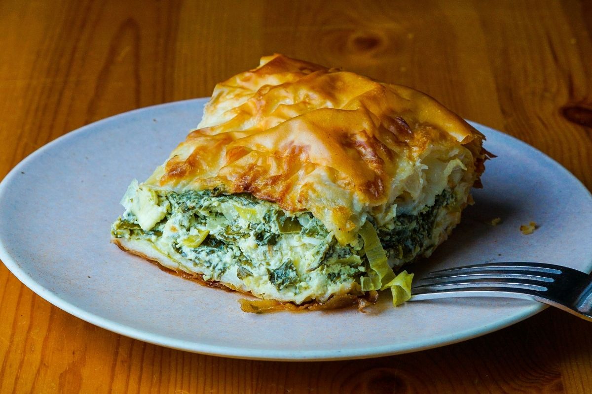 A slice of spanakopita silverbeet pie on a plate