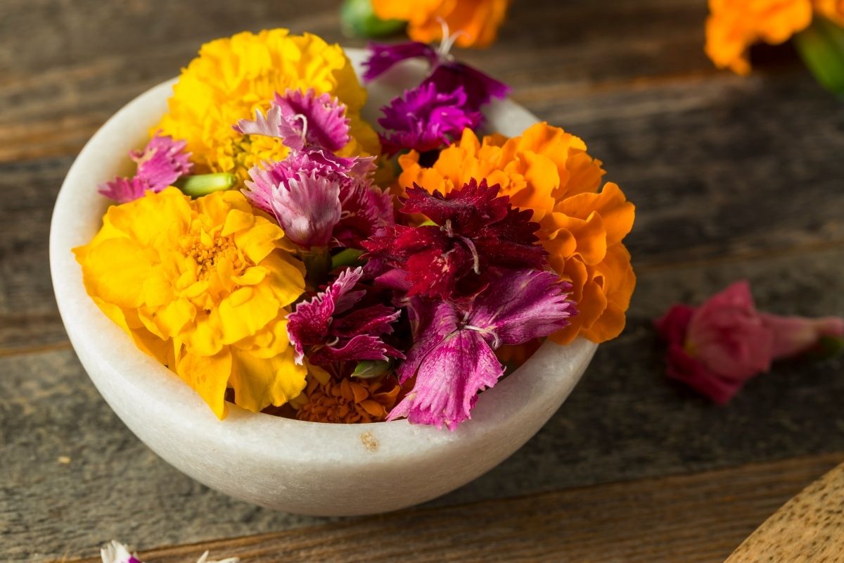 Edible flowers including marigolds and pansies in a bowl